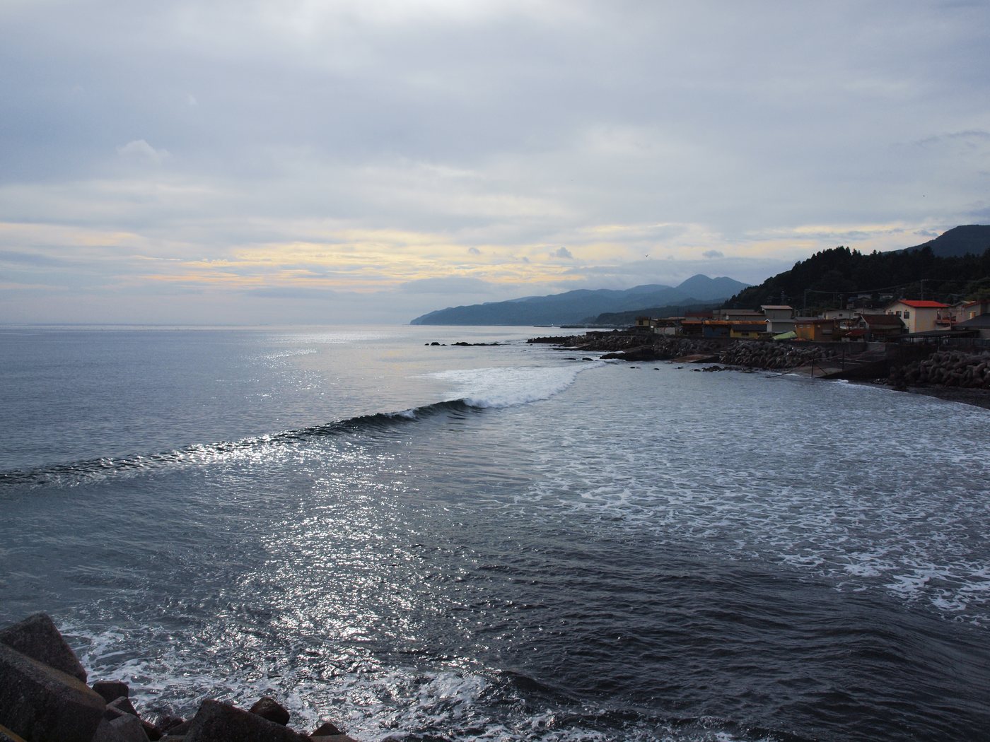 浜に寄せる波と、海沿いに並ぶ家並み